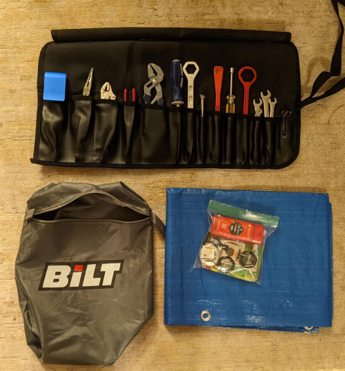 A tool roll, tarp, and tire patch kit on display.